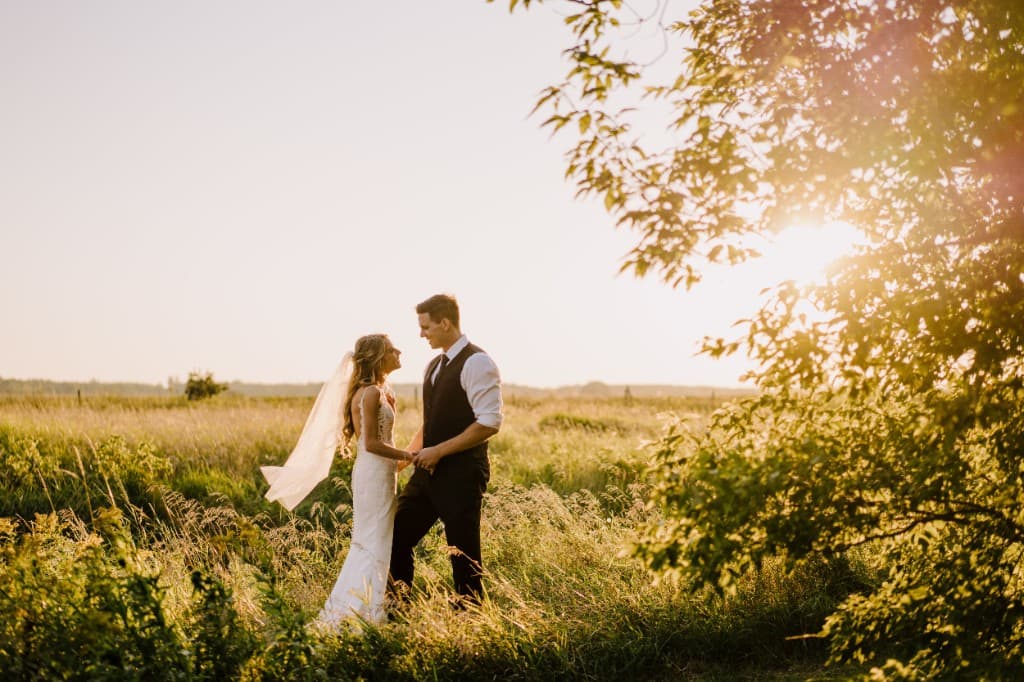 Spencer and Jenna on their wedding day in a prairie field at sunset